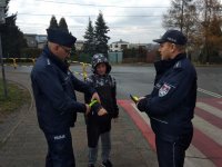 na zdjęciu: policjanci wręczają odblask dziecku, Łaziska Górne