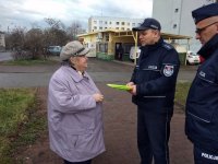 na zdjęciu: policjanci wręczają odblaskową opaskę starszej kobiecie, Łaziska Górne