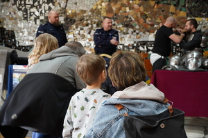 dzieci przyglądają się stojącym za stolikiem policjantom